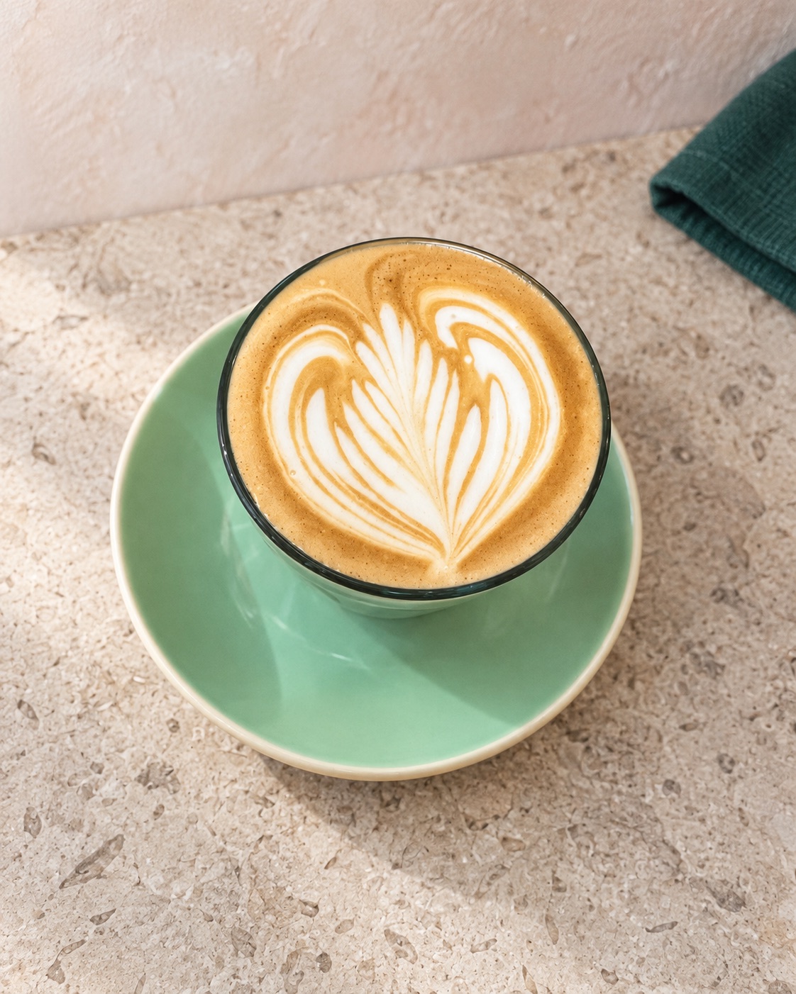 A fresh latte on a mint saucer